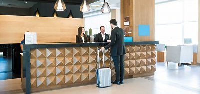 Two clerks checking in a guest